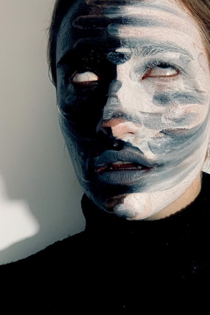pexels-photo-5783945-5783945 A mysterious and bold face painted in contrasting black and white tones, creating an artistic expression.